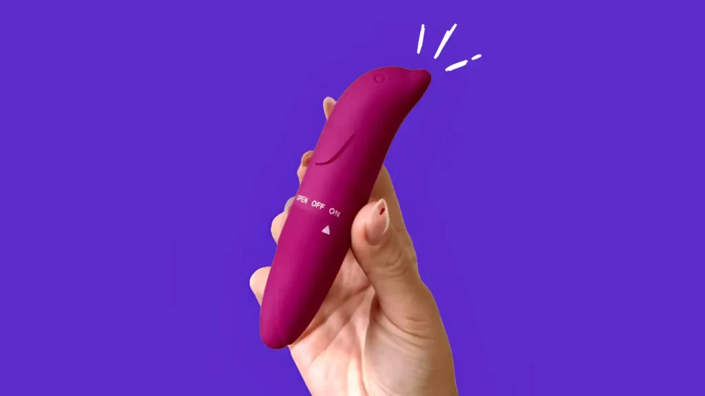 Mulher segurando um vibrador golfinho rosa